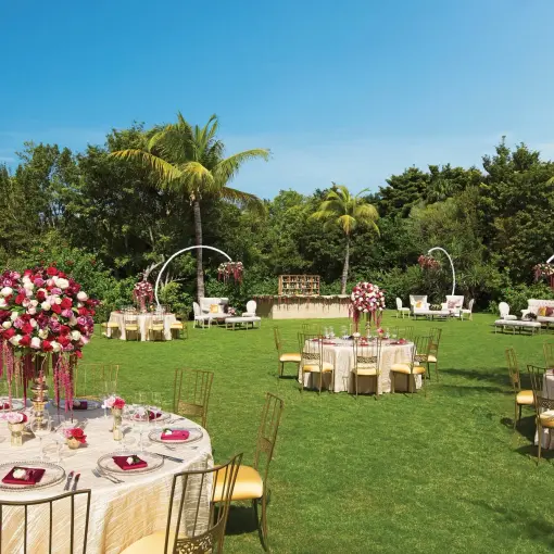 Garden wedding reception with floral centerpieces and round tables at Dreams Tulum, Tulum