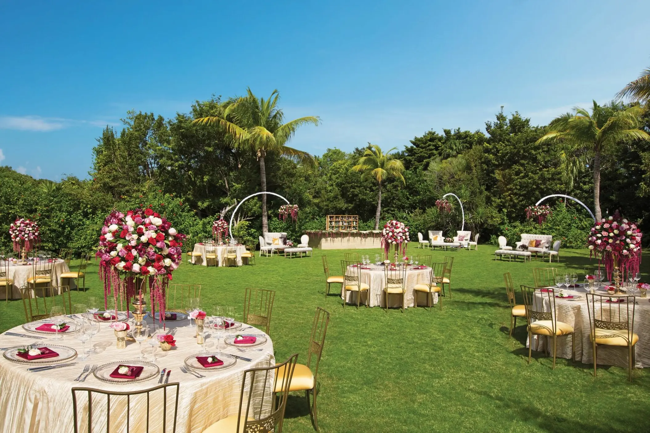 Garden wedding reception with floral centerpieces and round tables at Dreams Tulum, Tulum