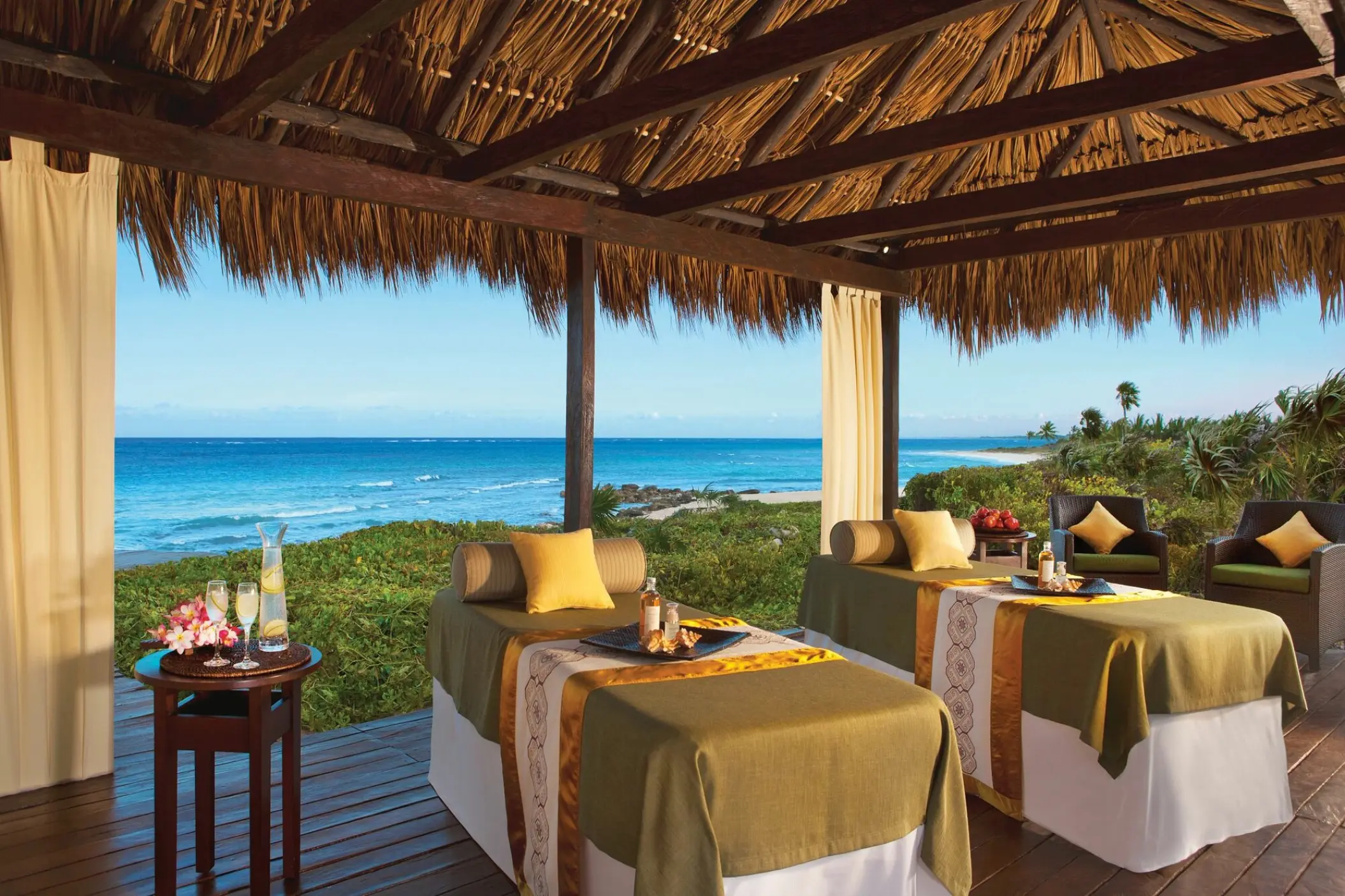 Oceanfront outdoor spa treatment tables under a palapa at Dreams Tulum, Tulum