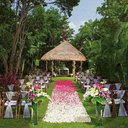 Secret Garden wedding ceremony with flower petal aisle and thatched gazebo at Dreams Tulum