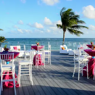 Oceanfront wedding reception setup with magenta linens on the terrace at Dreams Tulum, Tulum
