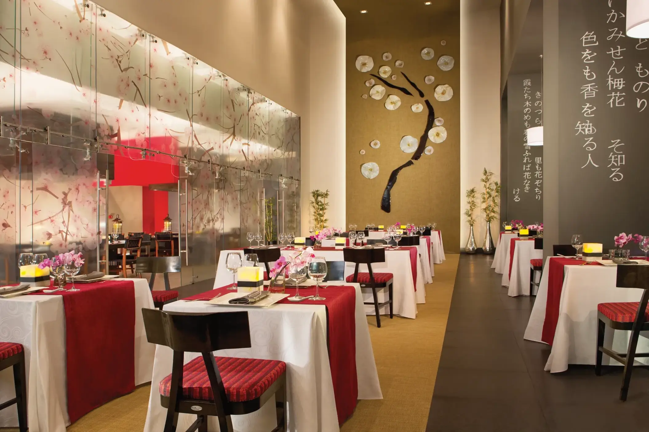 Asian restaurant with red and white linens and floral wall art at Dreams Vallarta Bay, Puerto Vallarta