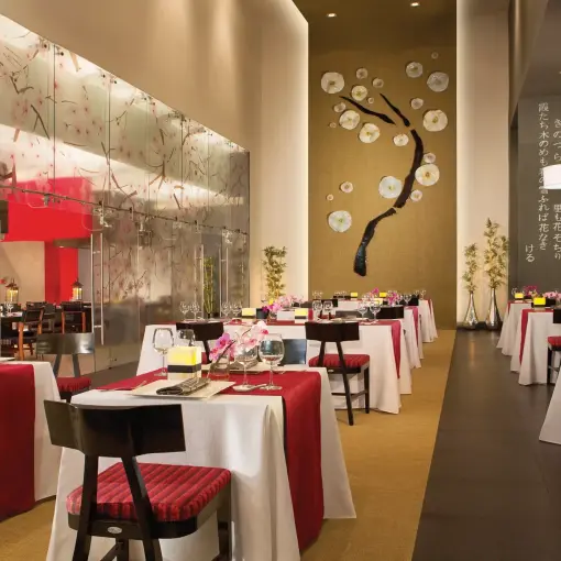 Asian restaurant with red and white linens and floral wall art at Dreams Vallarta Bay, Puerto Vallarta