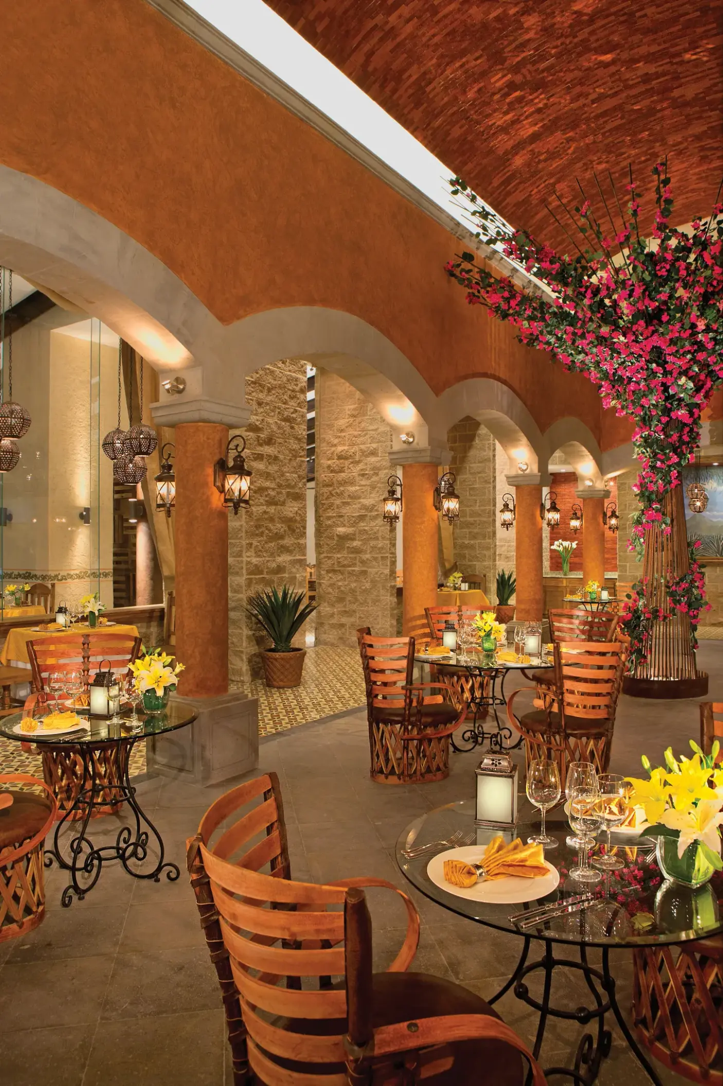 Tamarindo restaurant dining area with vaulted brick ceilings and pink floral decor at Dreams Vallarta Bay, Puerto Vallarta