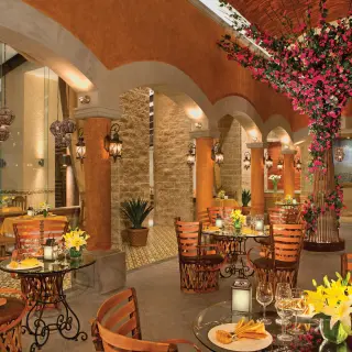 Tamarindo restaurant dining area with vaulted brick ceilings and pink floral decor at Dreams Vallarta Bay, Puerto Vallarta