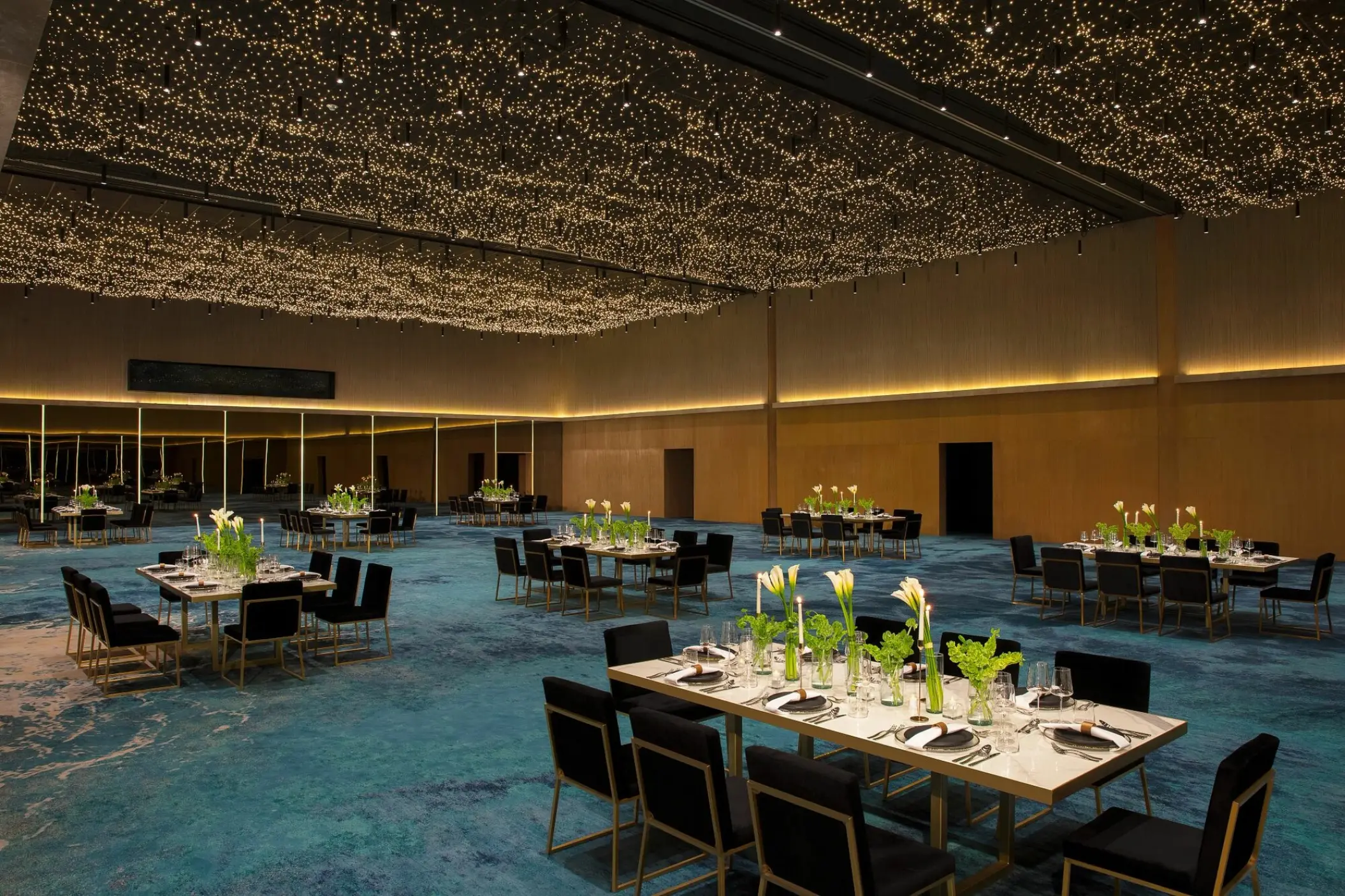 Indoor ballroom wedding reception at Dreams Vista Cancun featuring star-patterned lighting and blue floral carpet