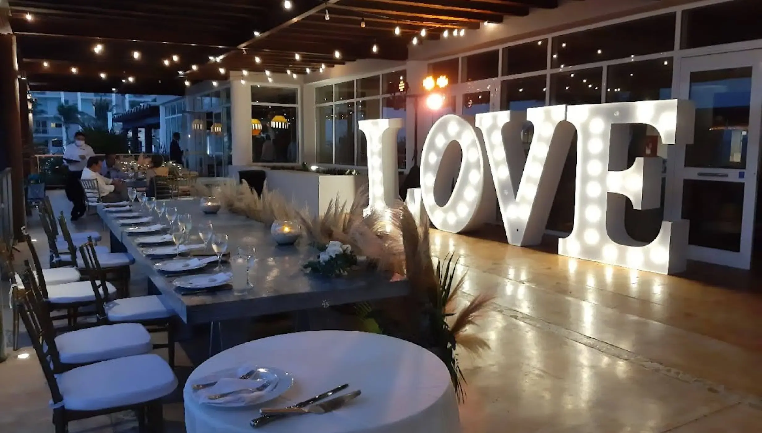 Wedding reception setup at Dreams Jade with marquee LOVE sign and string lights, Riviera Maya