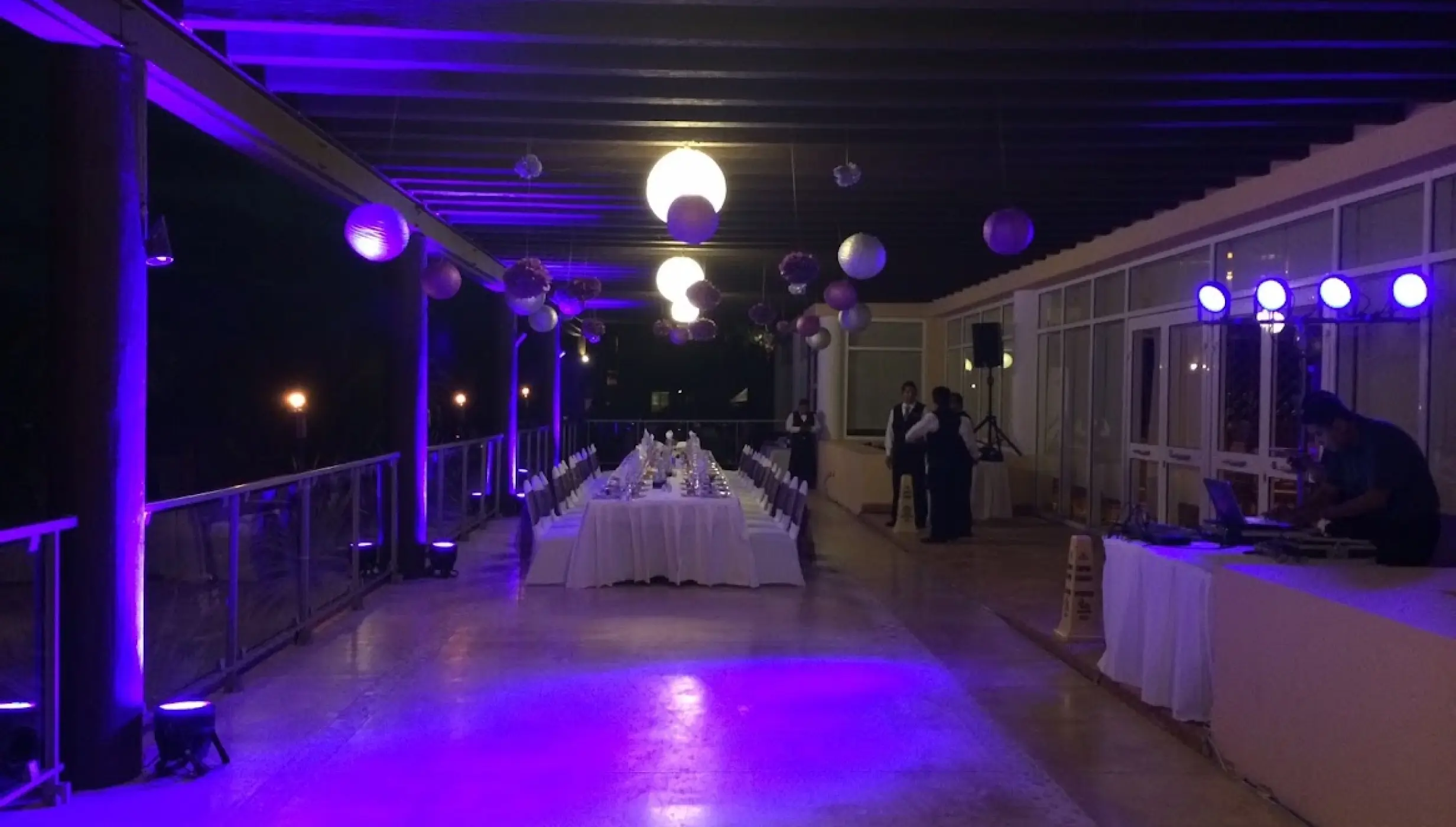 Wedding reception with purple uplighting and a long banquet table at Dreams Jade, Riviera Maya
