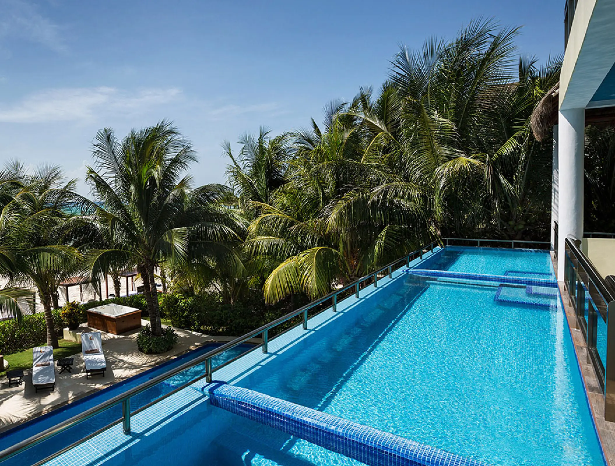 El Dorado Maroma rooftop infinity pool surrounded by palm trees, Riviera Maya