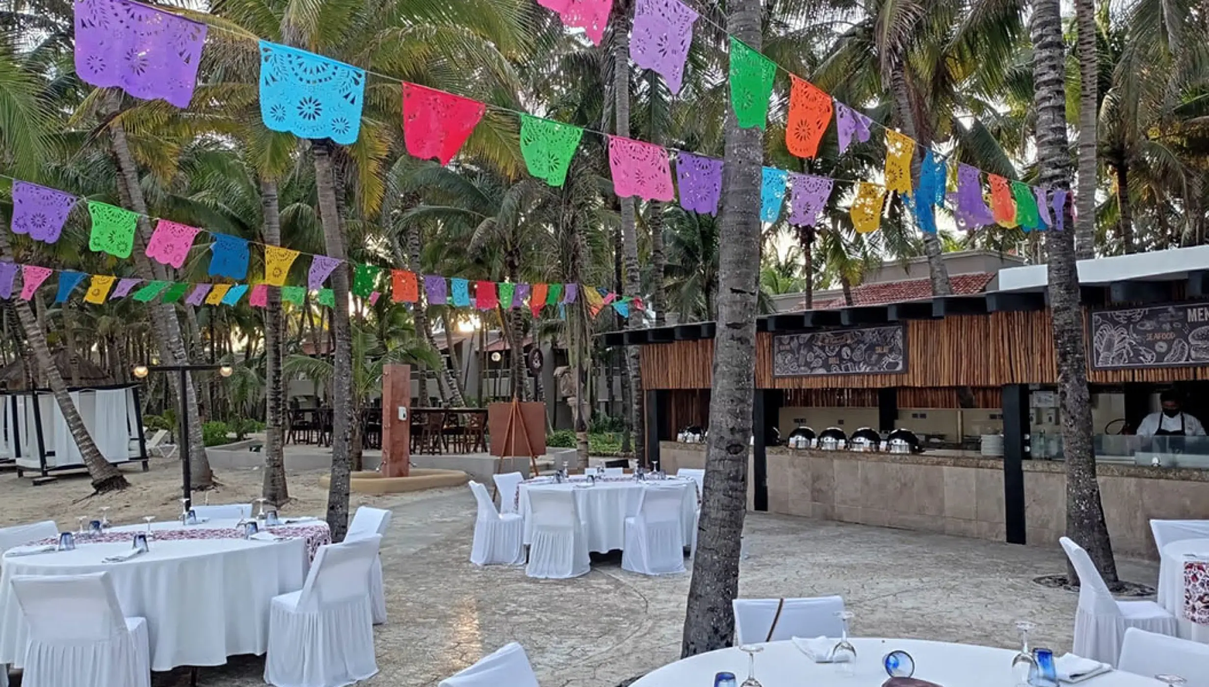 white gazebo soroundings with reception setup at El dorado Seaside Suites