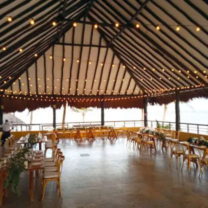 Palapa wedding reception with string lights and ocean views at El Dorado Seaside Suites, Riviera Maya
