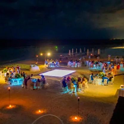 Nighttime beach wedding reception with glowing dance floor at El Dorado Maroma, Riviera Maya