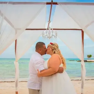 Couple kissing under a beach ceremony huppah at El Dorado Maroma, Riviera Maya