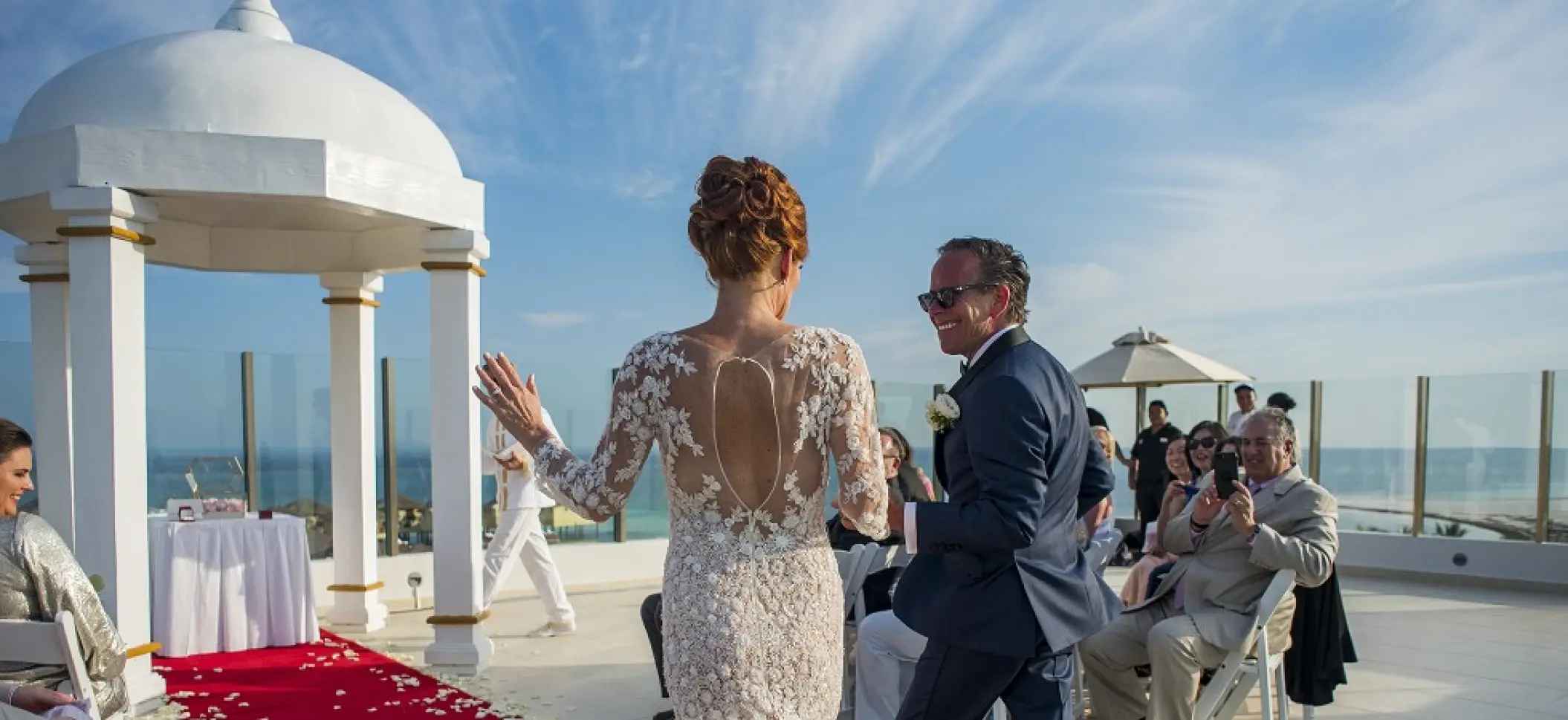 Bride and groom walking down the aisle at a sky deck wedding ceremony at El Dorado Maroma, Riviera Maya