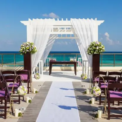 Sky deck wedding ceremony with purple chairs and white pergola at El Dorado Maroma, Riviera Maya