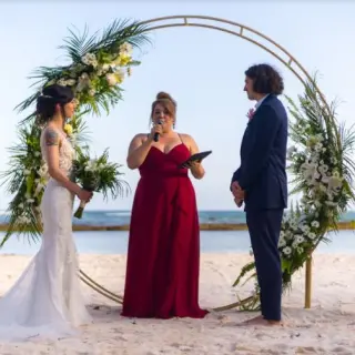 Beachfront wedding ceremony with a circular gold floral arch at El Dorado Seaside Palms, Riviera Maya