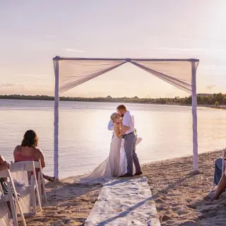 The couple kissing during a beach ceremony at El Dorado Seaside Palms, Riviera Maya