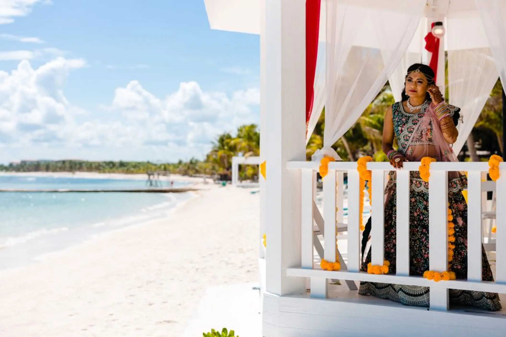 Bride in a traditional lehenga standing in a beach gazebo at El Dorado Seaside Palms, Riviera Maya