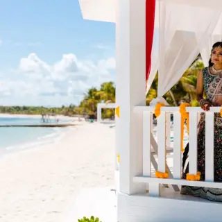 Bride in a traditional lehenga standing in a beach gazebo at El Dorado Seaside Palms, Riviera Maya