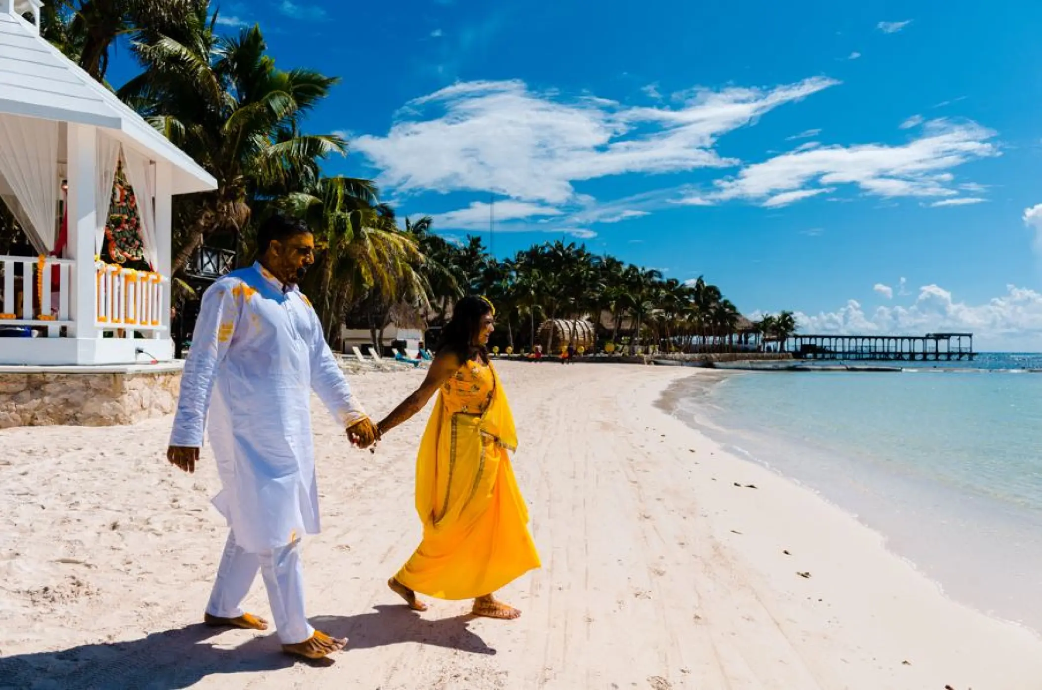 Couple walking along the white sand beach at El Dorado Seaside Palms, Riviera Maya