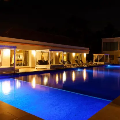 Cotorros pool with cabanas illuminated at night at El Dorado Seaside Palms, Riviera Maya