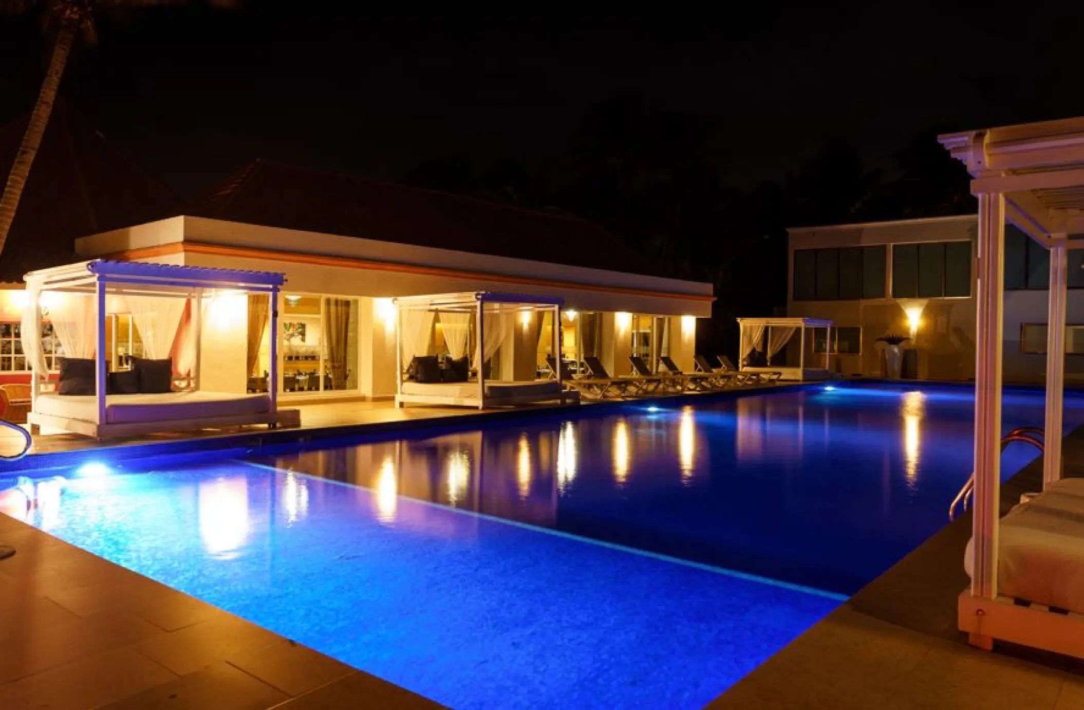 Cotorros pool with cabanas illuminated at night at El Dorado Seaside Palms, Riviera Maya