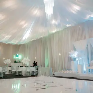 Grand ballroom wedding reception with white draped ceiling and dance floor at El Dorado Seaside Palms, Riviera Maya