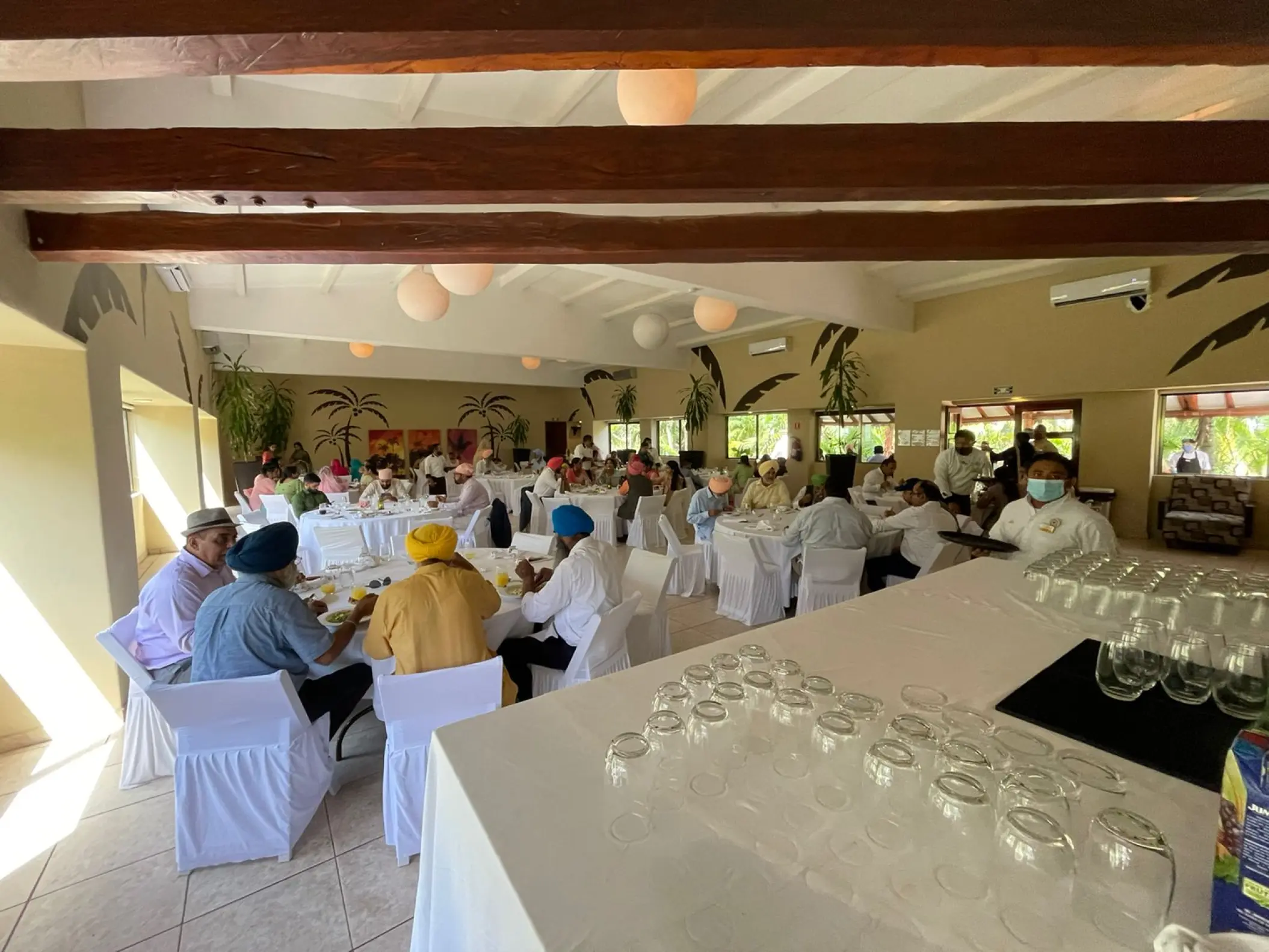 Indoor wedding reception with round tables and white linens at El Dorado Seaside Palms, Riviera Maya