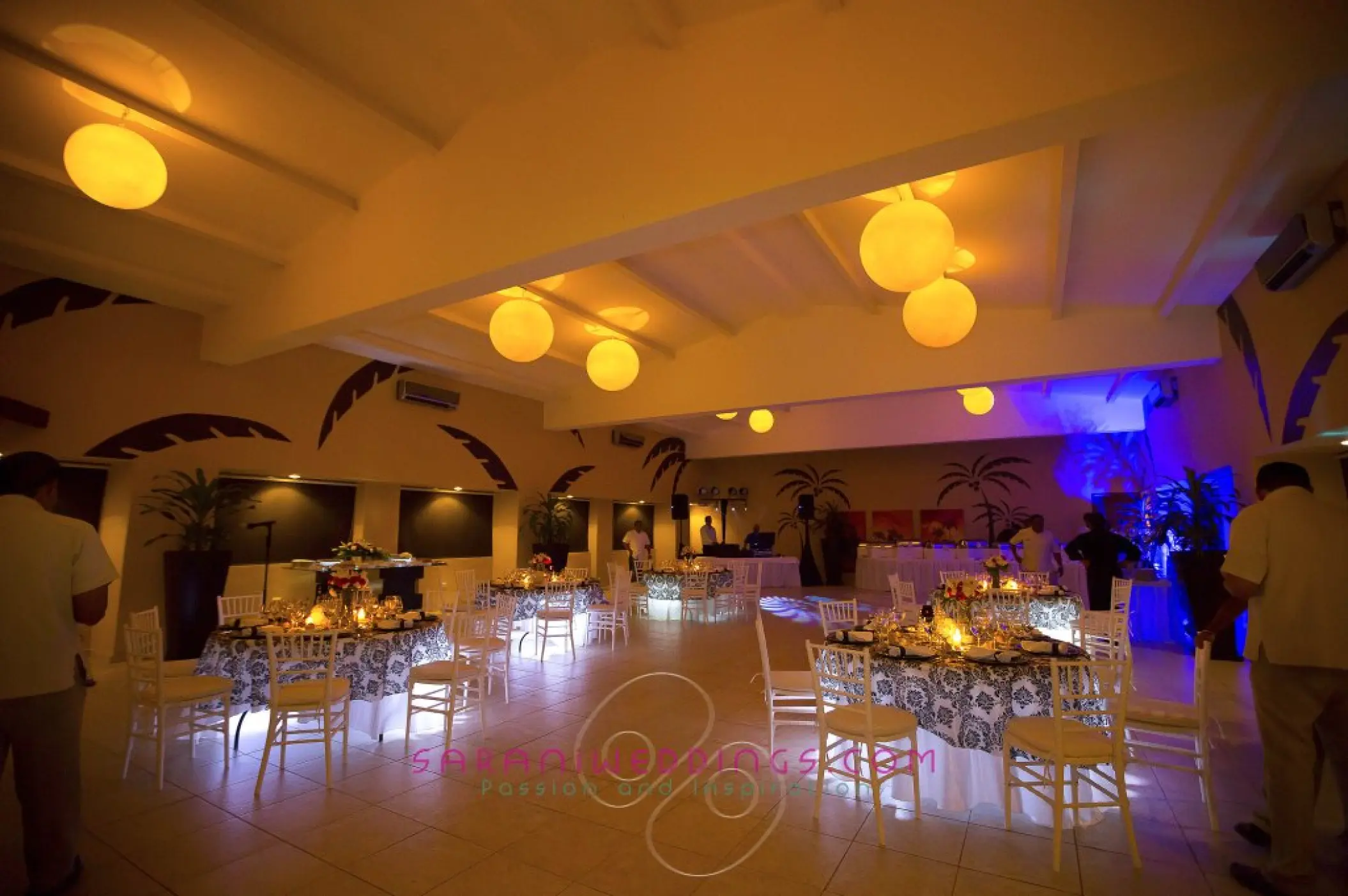 Indoor wedding reception with glowing lanterns and floral centerpieces at El Dorado Seaside Palms, Riviera Maya