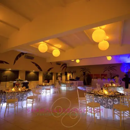 Indoor wedding reception with glowing lanterns and floral centerpieces at El Dorado Seaside Palms, Riviera Maya
