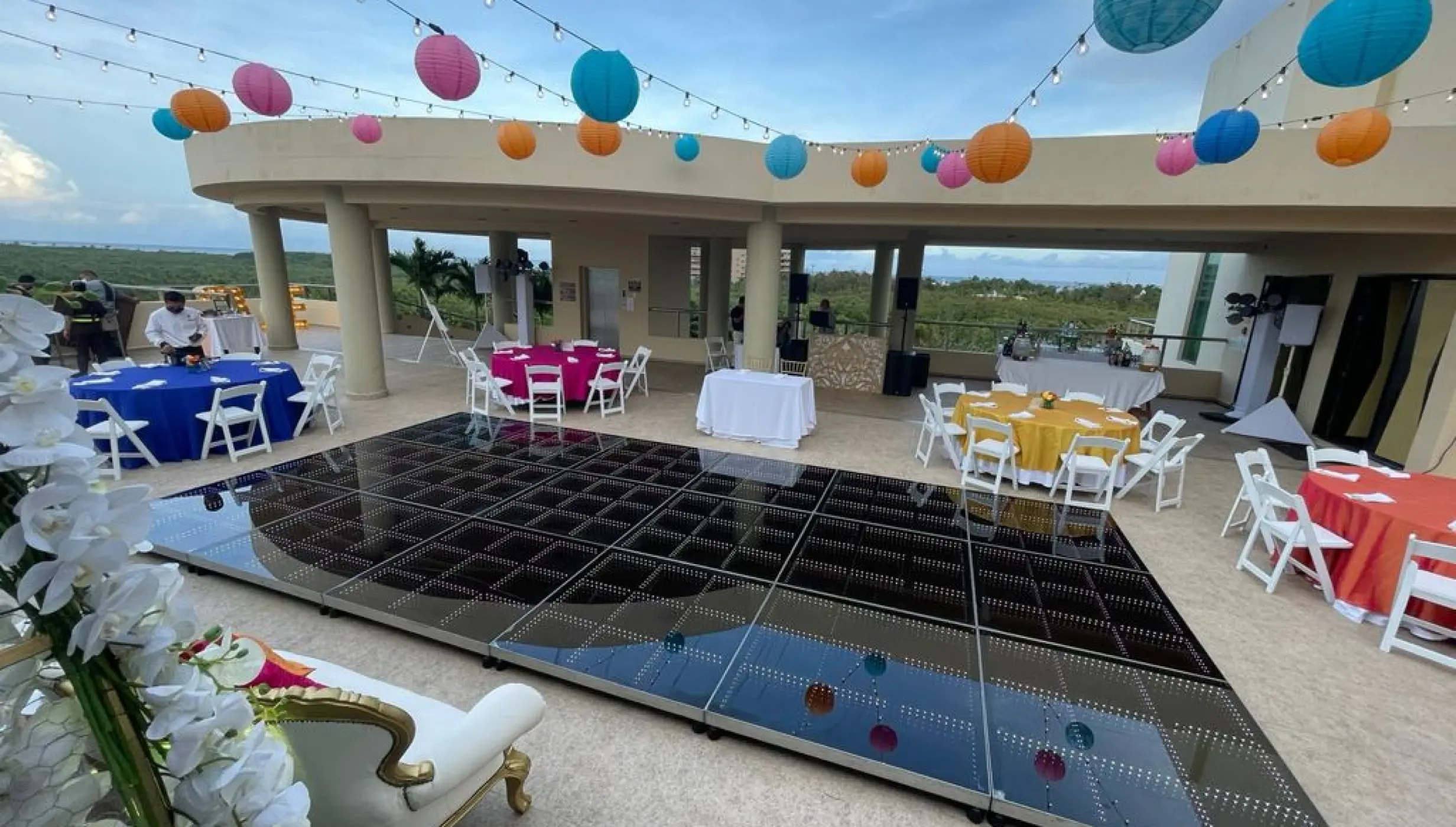 Rooftop wedding reception with a dance floor and colorful paper lanterns at El Dorado Seaside Palms, Riviera Maya