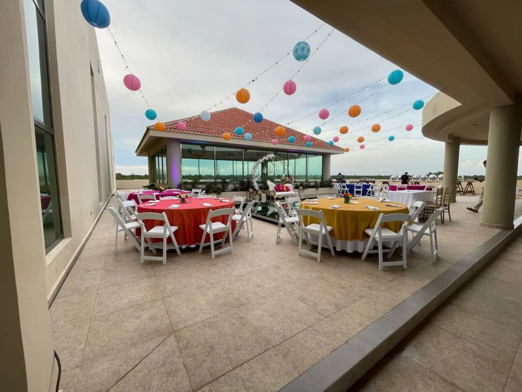 Sky deck wedding reception with colorful lanterns and table linens at El Dorado Seaside Palms, Riviera Maya