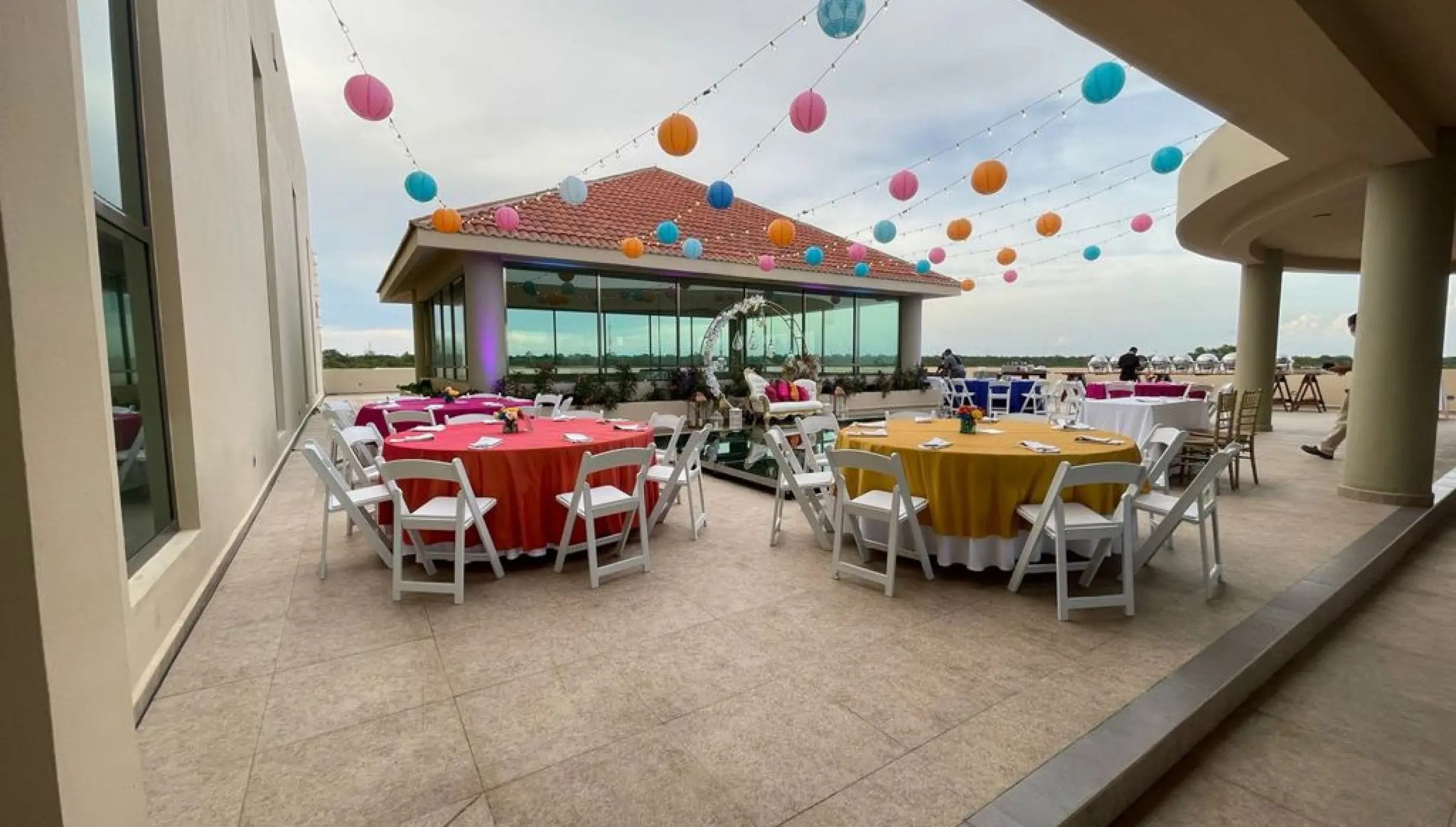 Sky deck wedding reception with colorful lanterns and table linens at El Dorado Seaside Palms, Riviera Maya
