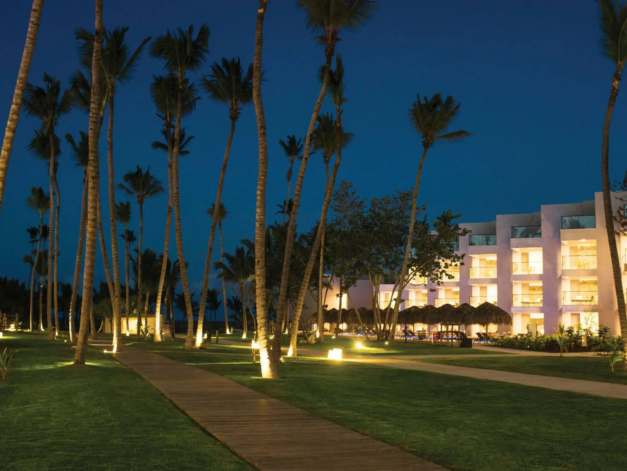 Excellence El Carmen lit pathways and modern suites at night, Punta Cana