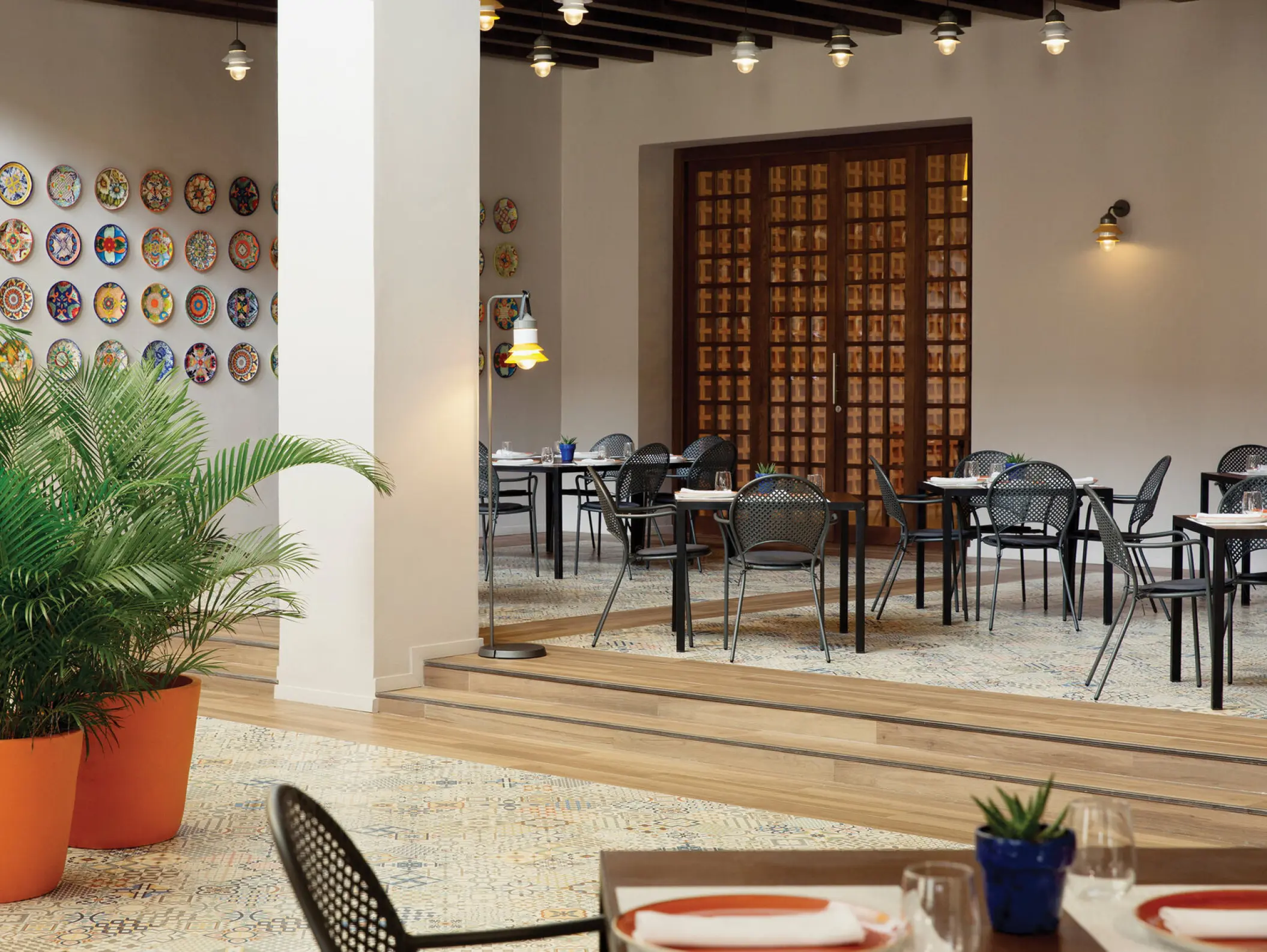 Agave restaurant dining area with decorative plates on the wall at Excellence El Carmen, Punta Cana