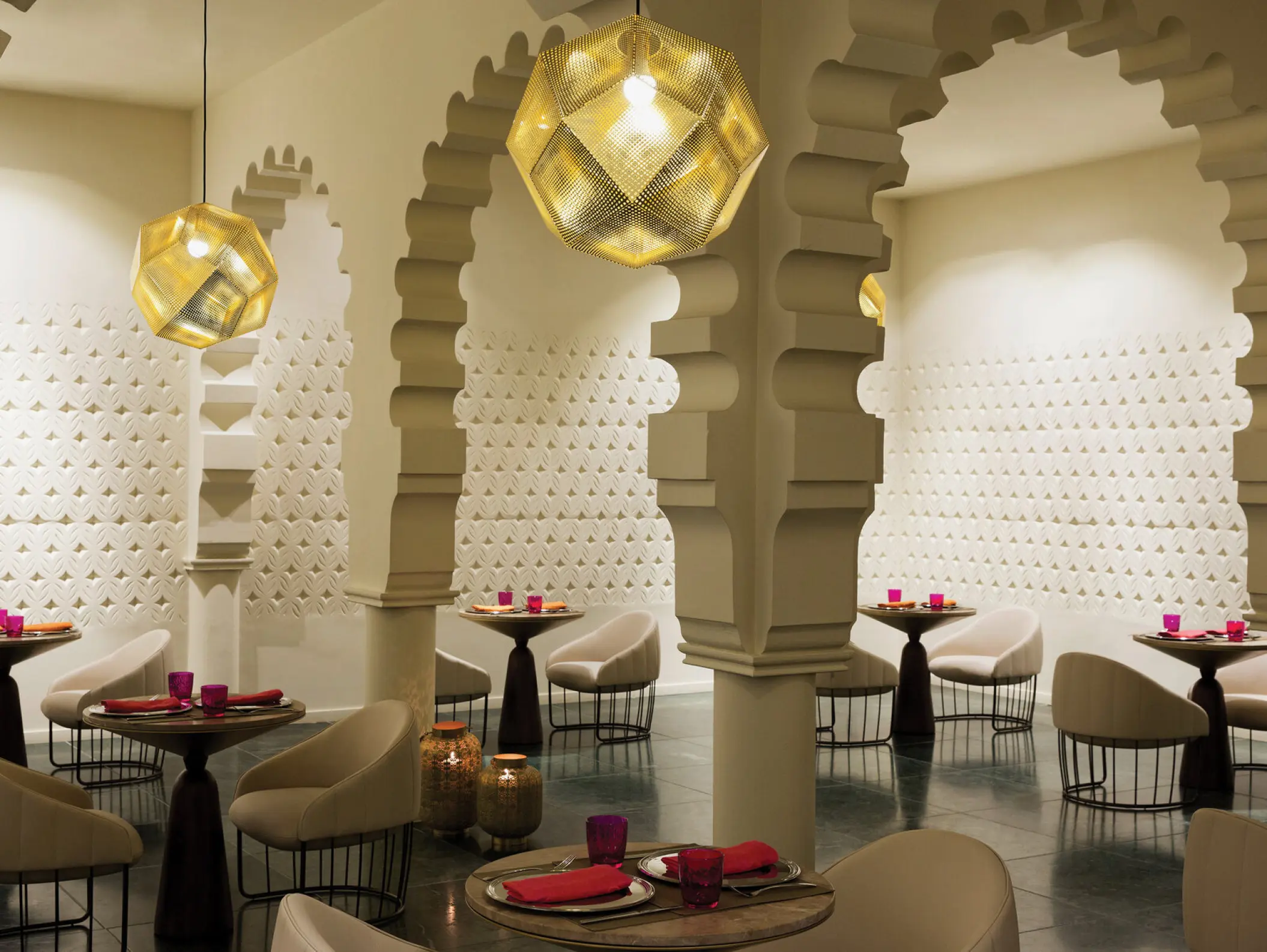 Basmati restaurant dining area with ornate arches and gold geometric lamps at Excellence El Carmen, Punta Cana