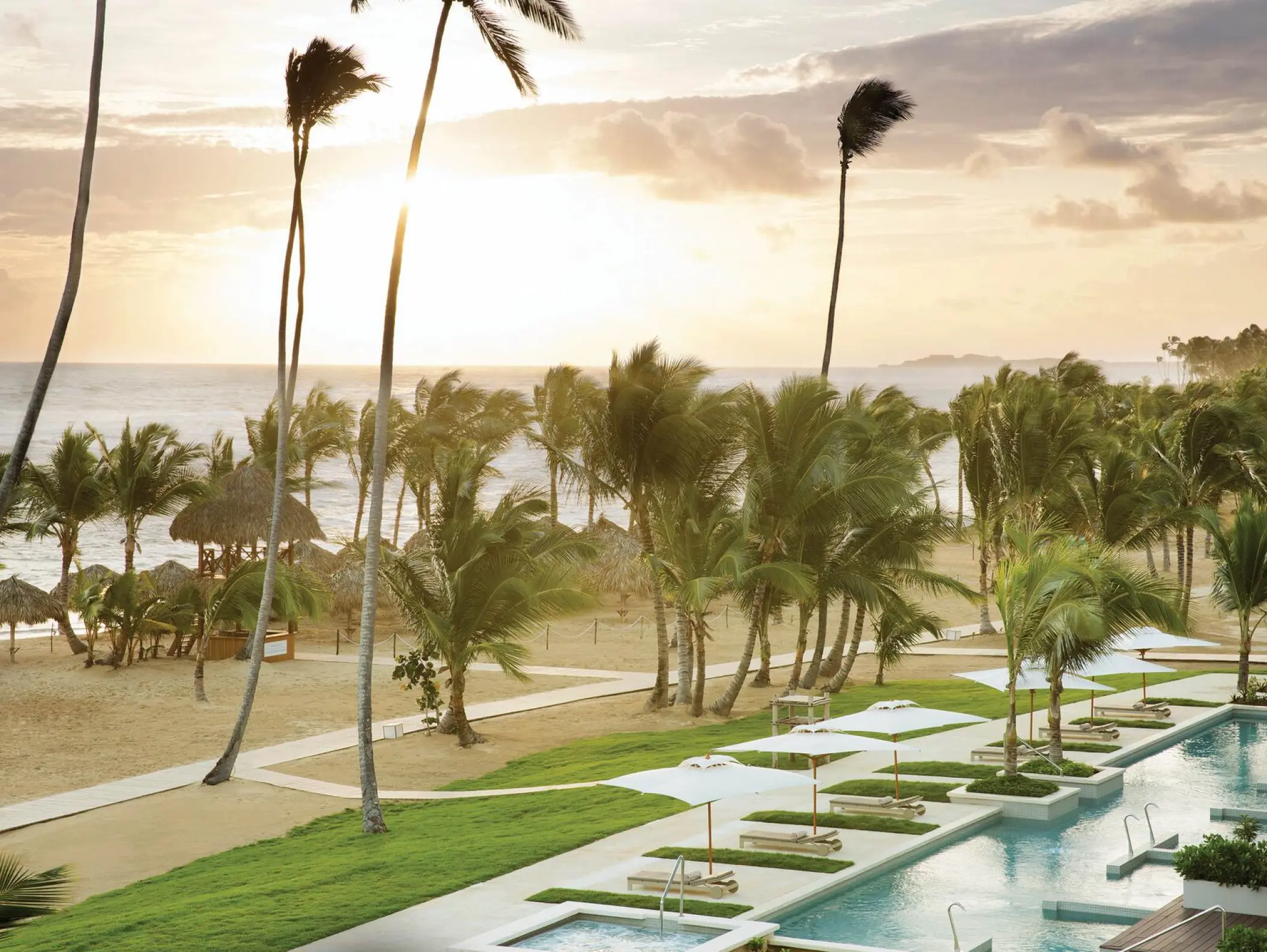 Excellence El Carmen beachfront pools and palm trees at sunset, Punta Cana