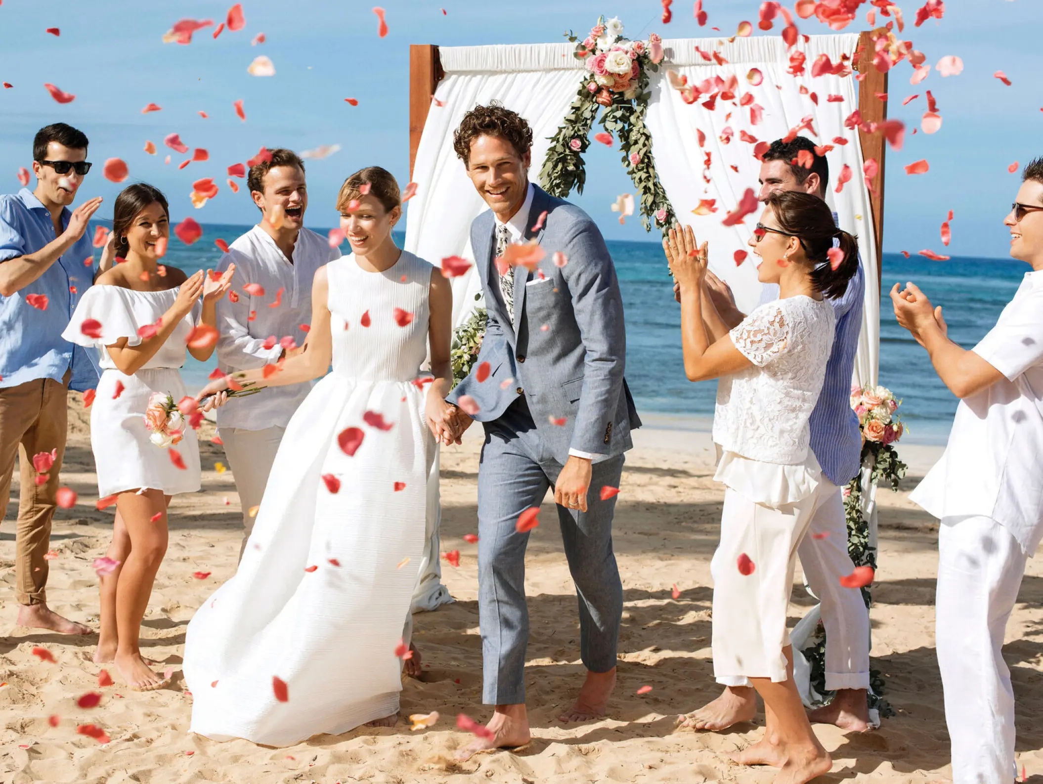 Petal toss celebrating a couple during a beach ceremony at Excellence El Carmen, Punta Cana
