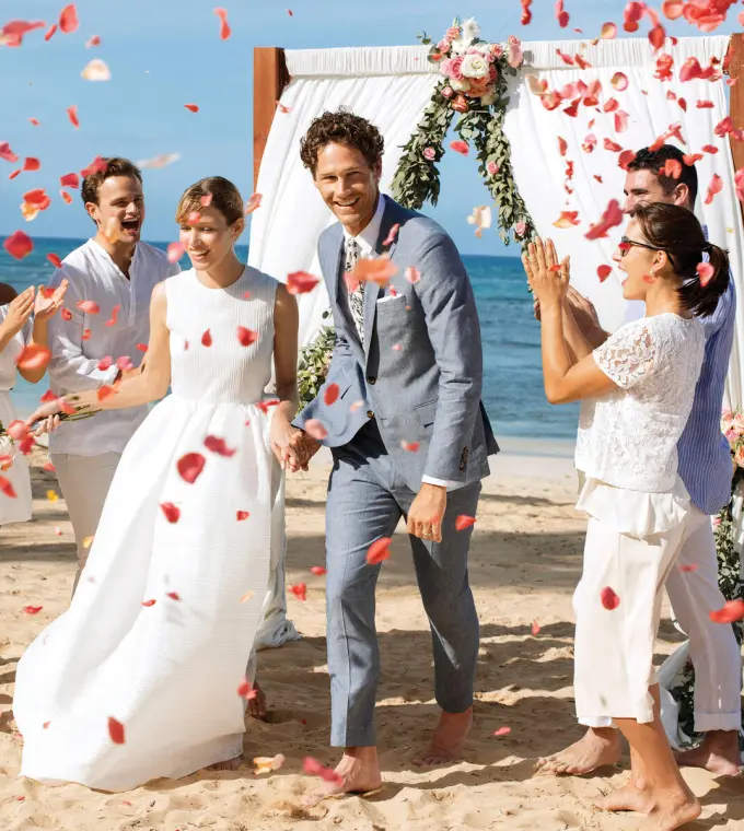 Petal toss celebrating a couple during a beach ceremony at Excellence El Carmen, Punta Cana