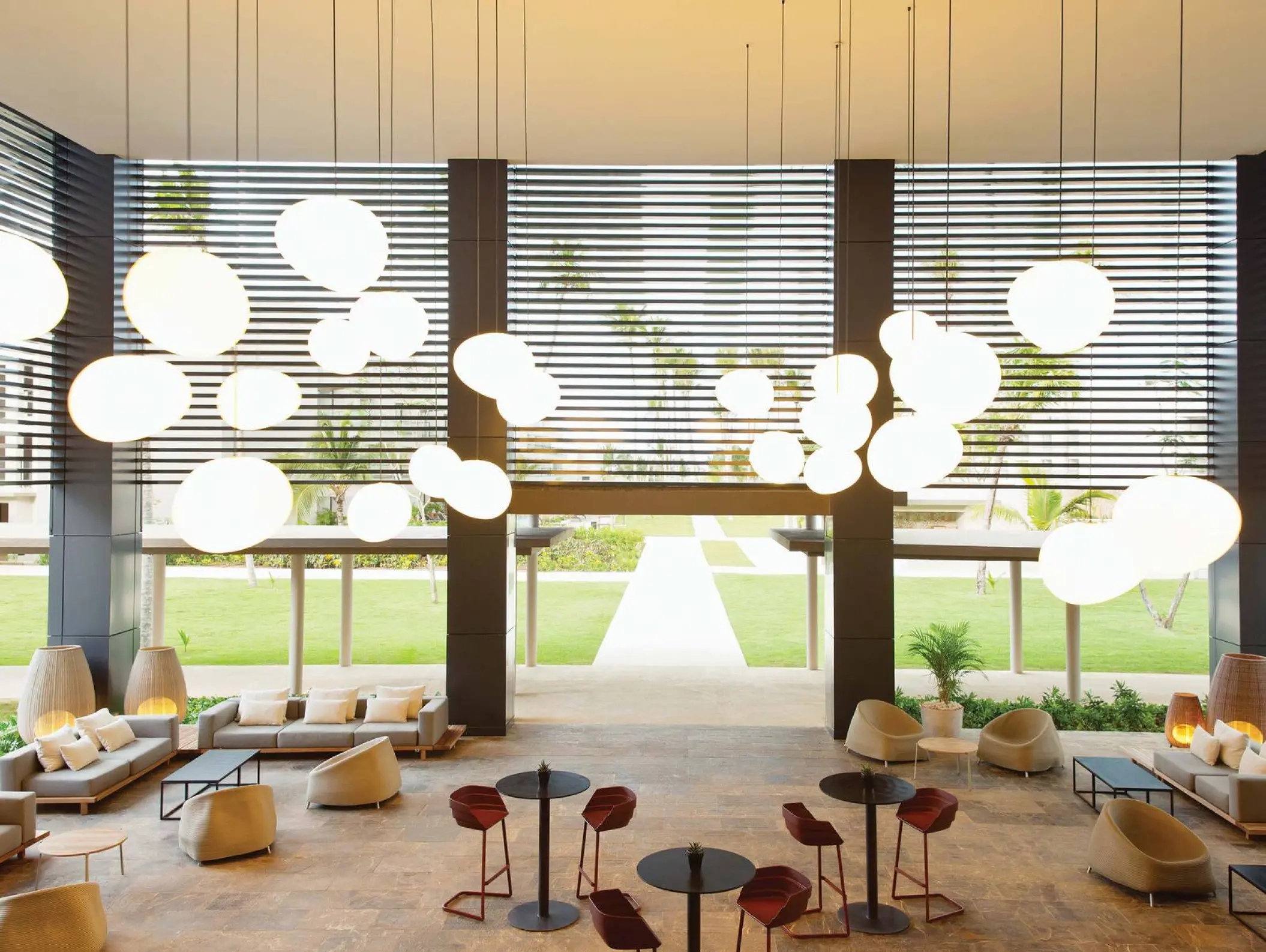 Modern open-air lobby lounge with hanging globe lights at Excellence El Carmen, Punta Cana