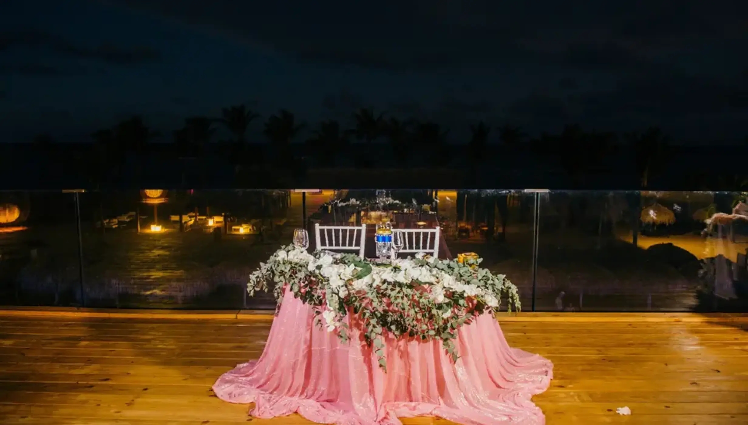 Terrace wedding reception sweetheart table with pink linens and flowers at Excellence El Carmen, Punta Cana