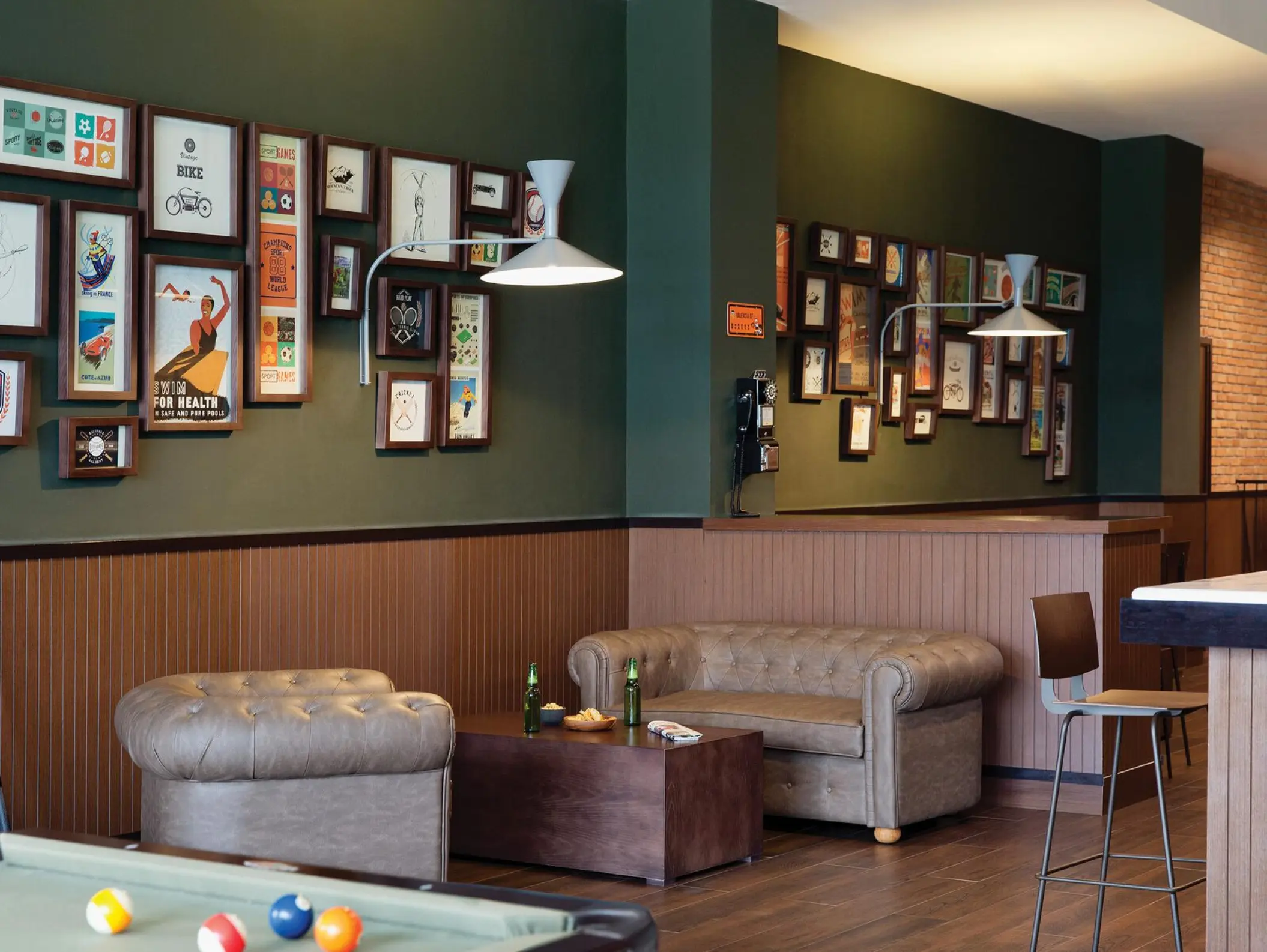 Sports bar interior with tufted sofas, pool table, and framed art at Excellence El Carmen, Punta Cana