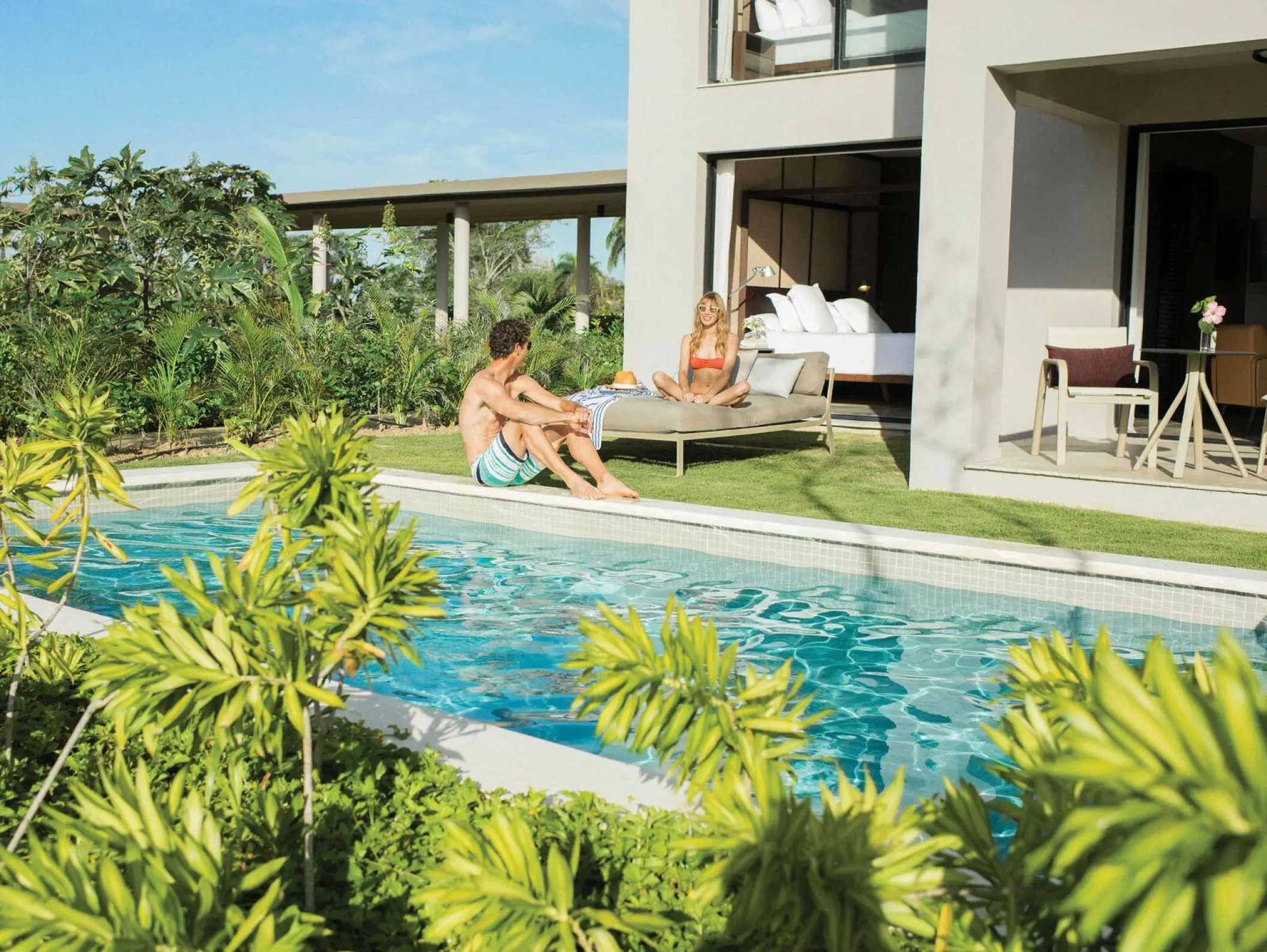 Private swim-up suite with a couple lounging by the pool at Excellence El Carmen, Punta Cana