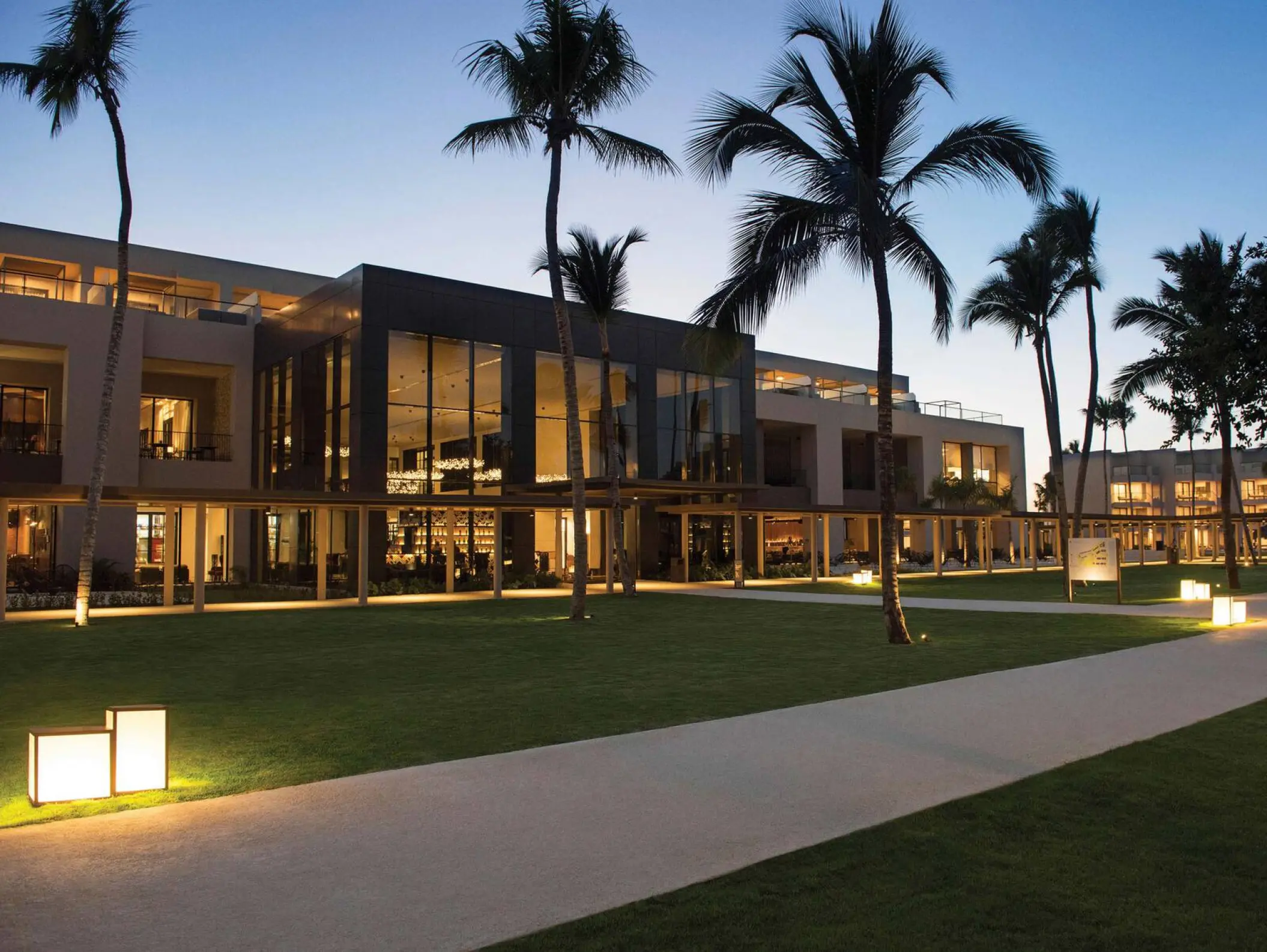 Excellence El Carmen modern exterior and lit walkways at dusk, Punta Cana