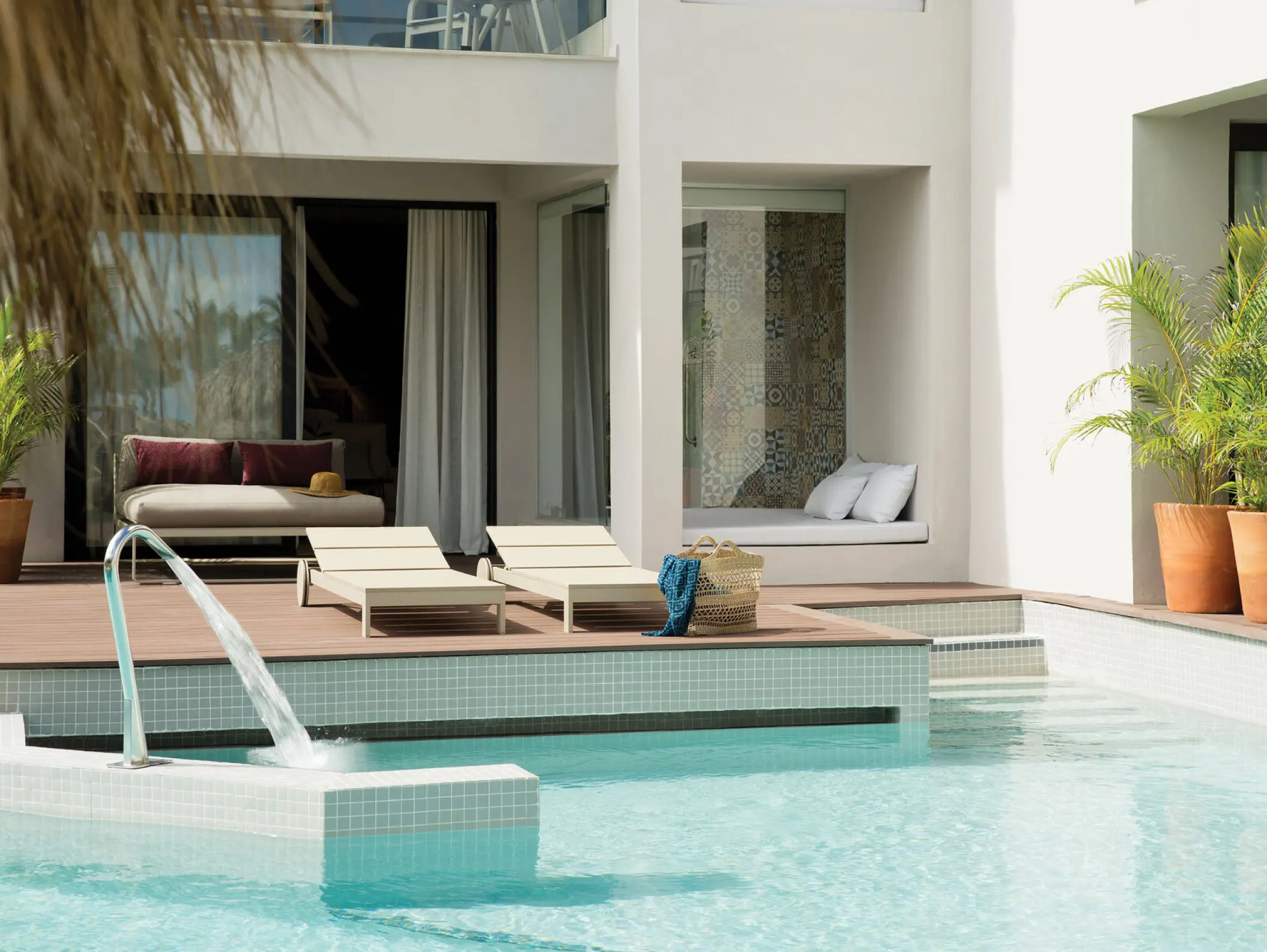 Swim-up suite terrace with lounge chairs and pool fountain at Excellence El Carmen, Punta Cana