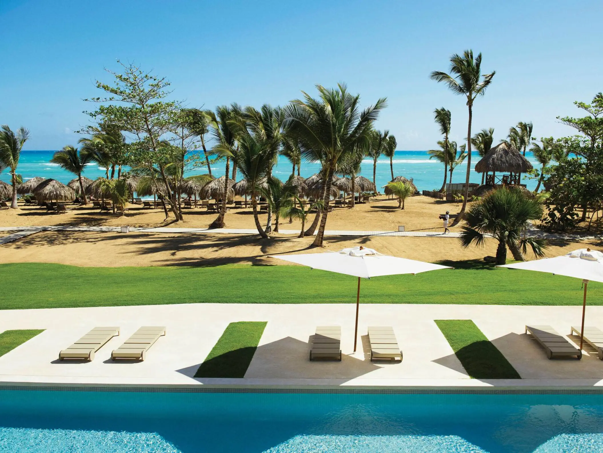 Swim-up pool and lounge deck overlooking the beach at Excellence El Carmen, Punta Cana