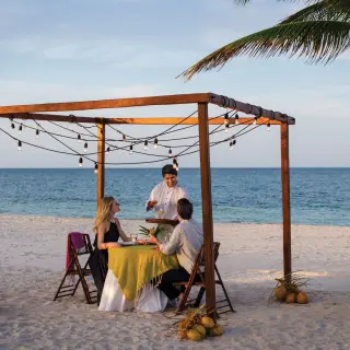 Private beach dinner for a couple under a wooden pergola at Excellence Playa Mujeres, Cancun