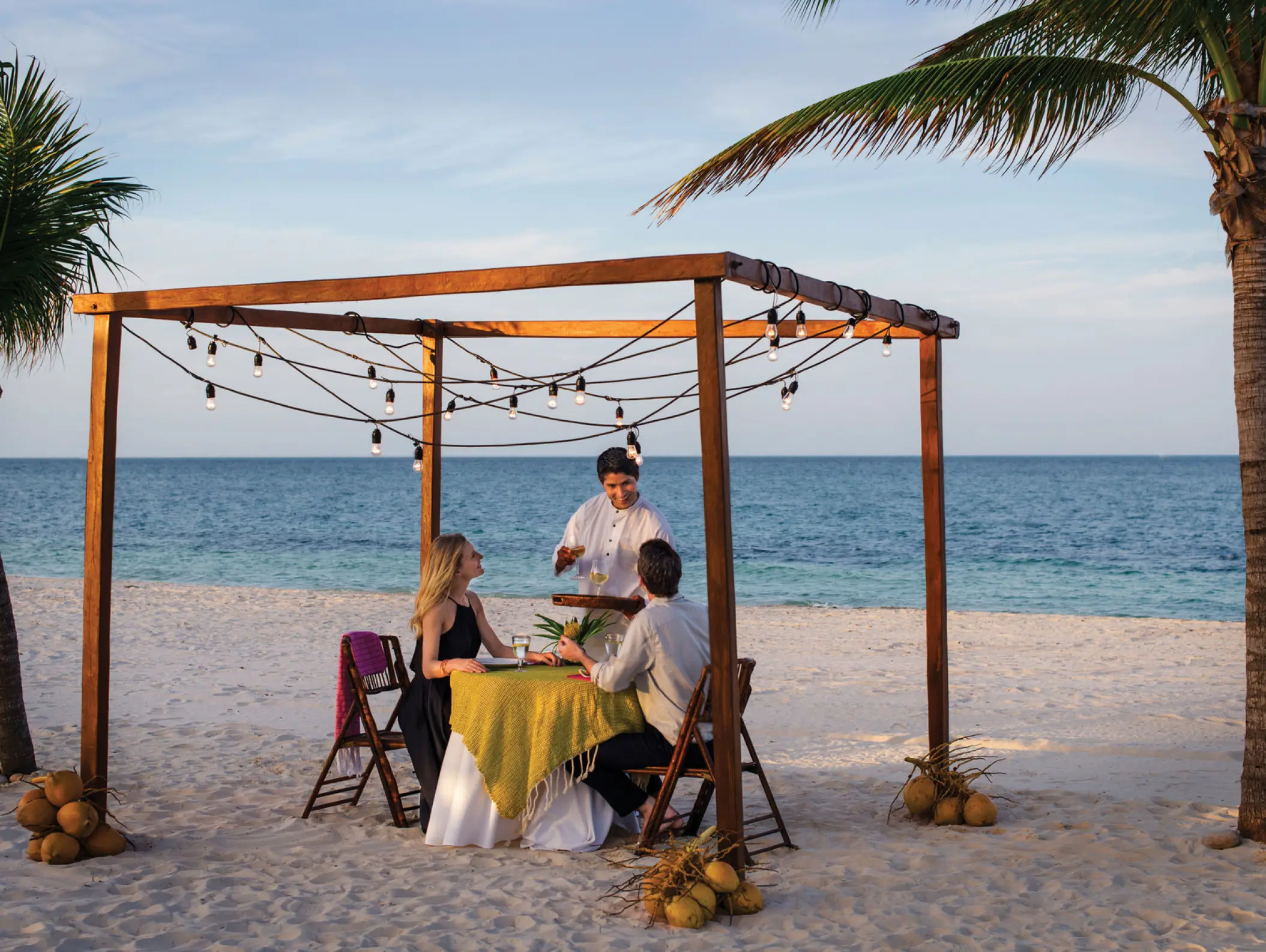 Private beach dinner for a couple under a wooden pergola at Excellence Playa Mujeres, Cancun