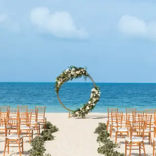 Circular floral arch for a beach wedding ceremony at Excellence Playa Mujeres, Cancun