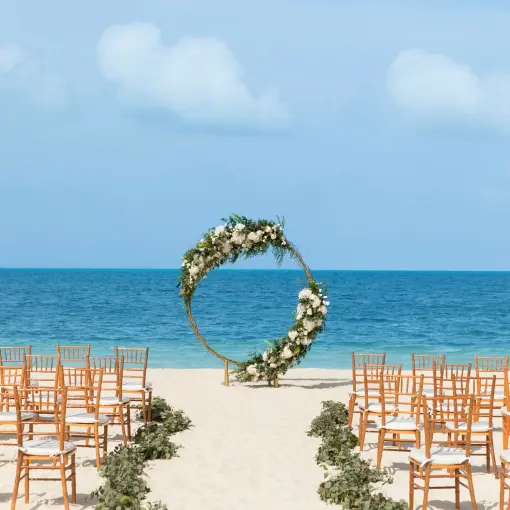 Circular floral arch for a beach wedding ceremony at Excellence Playa Mujeres, Cancun